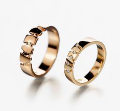 two gold wedding rings with diamonds on each one and the other in different sizes, all set against a white background