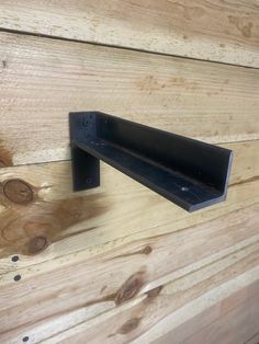 a piece of wood that is on the side of a wooden wall with metal brackets