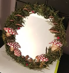 a wreath made out of moss and mushrooms on top of a sheet of white paper