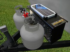 two propane tanks sitting on top of a trailer with solar panels attached to the tank