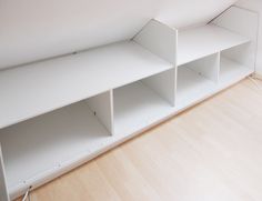 an empty white shelf in the corner of a room with wood flooring and hard wood floors