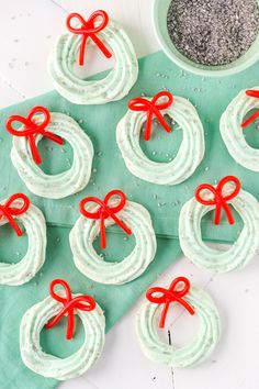 small pretzels with red bows on them sitting next to a bowl of black sand