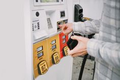 a woman is filling up her car with gas at a gas station, closeup