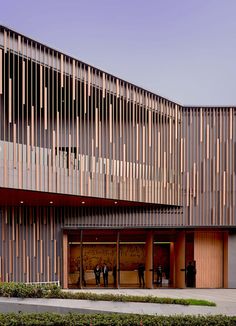 two people standing in front of a building with wooden slats on the walls and doors