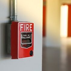 a red fire hydrant mounted to the side of a wall