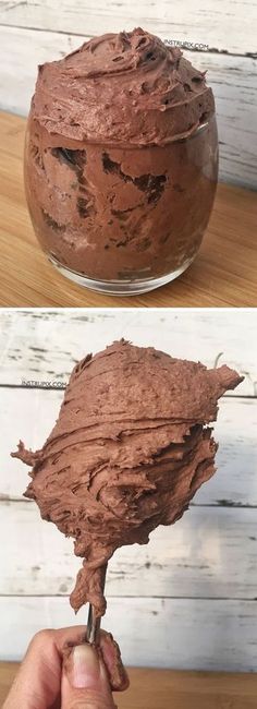 there is a chocolate cake in a glass bowl on top of a wooden table and the bottom has been frosted with icing