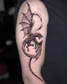 a black and white dragon tattoo on the arm