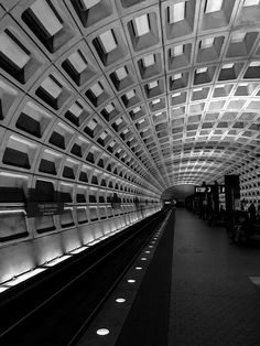 an empty subway station with people waiting for the train