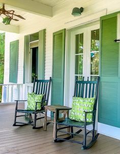 two rocking chairs on the front porch of a house