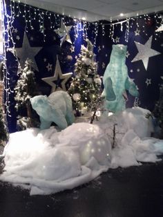 a christmas display in an office cubicle with snow and stars on the wall,