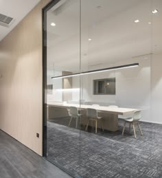 an empty conference room with glass walls and chairs