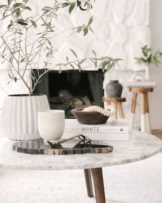 a white table topped with a book next to a plant