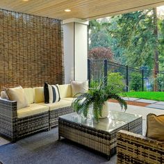 an outdoor living room with wicker furniture