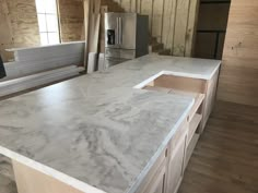 a kitchen counter top with an oven and refrigerator in the middle of it, surrounded by unfinished wood planks