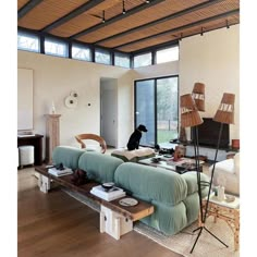 a living room filled with lots of furniture and a dog sitting on top of the couch