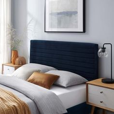 a bedroom with a blue headboard and white bedding