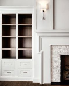 a white bookcase in front of a fireplace