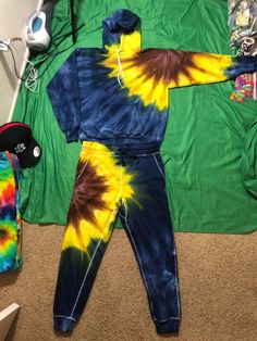 a child's tie - dyed outfit laying on the floor next to other items