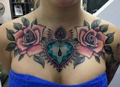 a woman with tattoos on her chest is wearing a blue dress and has three roses