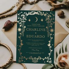 a green and gold wedding card on top of a table next to some other items