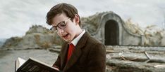 a young boy in glasses reading a book