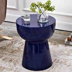 a blue table with two vases on it and a white rug in the background