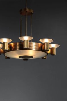 a chandelier with five lights hanging from it's sides and four lamps on each side