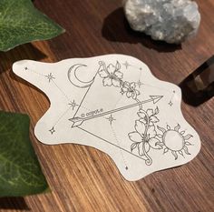 a sticker with an image of the sun and moon on it next to some leaves