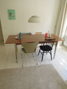 a dining room table with chairs and a rug on the floor