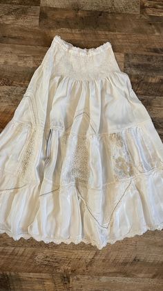 Boho white skirt with lace panels, made from 100% viscose.  The waist features an elastic band measuring 30 cm, and the skirt length is 87 cm. Made in Italy, it has a soft flow and a unique patchwork design.  Please note there is a slight mark (black stripe as shown in the photo), but it is barely noticeable when worn. Boho Patchwork, White Lace Skirt, Skirt With Lace, White Skirt, Patchwork Designs, Lace Panelled, White Skirts, Skirt Length, Black Stripes