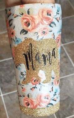 a person holding up a cup with the word mama on it in gold glitters