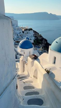 white buildings with blue domes overlook the ocean