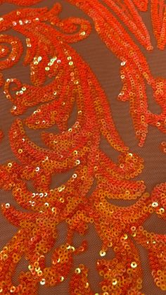 an orange and gold fabric with sequins on it