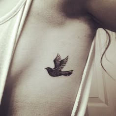 a small bird tattoo on the chest is shown in black and white photo, it appears to be flying