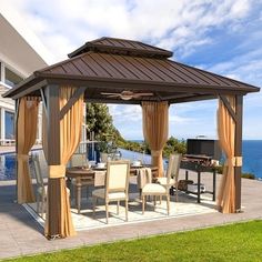 an outdoor gazebo with curtains on the side of it near a swimming pool and ocean