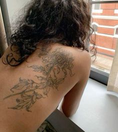 the back of a woman's body with tattoos on it