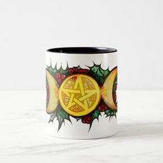 a coffee mug with a pentagram surrounded by fruit and leaves on it's side