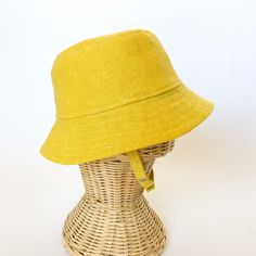 This yellow bucket hat is the perfect thing for babies toddlers and kids on sunny summer days! Washable linen and cotton fabirc makes it an easy go to for at the park, the beach, or even the backyard! This hat will protect delicate skin from the sun and will quickly become a favorite accessory! I made this sun hat from a bold yellow colored linen/cotton blend fabric. The strap closes with snaps under the chin keeps them from pulling it off. Brim measures approx. 2.25 inches. SIZES AVAILABLE 0-3 mos. - fits 14" to 16" head circumference 3-6 mos. - fits 15" to 17" head circumference 6-12 mos. - fits 16" to 18" head circumference 12-24 mos. - fits 17.5" to 19.5" head circumference Small (3 to 5 yrs) - fits 19" to 21" head circumference OVERVIEW + Sewn by me + Yellow Linen and Cotton blend Fab