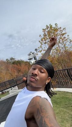 a man with his hand up in the air while standing next to a skateboard