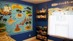 a child's bedroom decorated in blue and yellow with pirate map on the wall