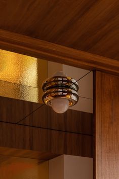 a light fixture hanging from the ceiling in a room with wood paneling and walls