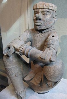 a statue of a man sitting on top of a table