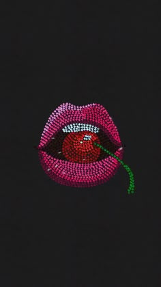 a close up of a lipstick with a flower in it's mouth on a black background