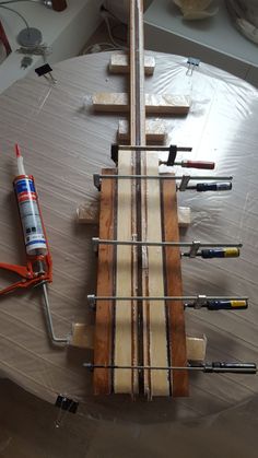 an electric guitar is being worked on with wood and wire, along with other tools