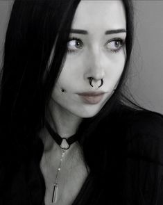 a woman with black hair and nose piercings