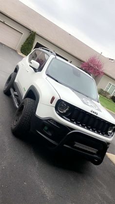 a white jeep parked in front of a house