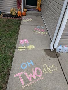 chalk drawings on the sidewalk in front of a house that says, oh two sides