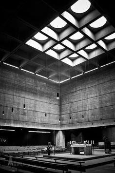 an empty church with pews and lights on the ceiling, in black and white