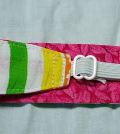 a pink and green striped belt with a white metal buckle on it's end