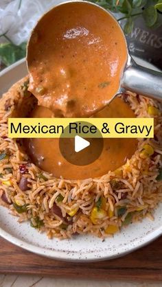 the mexican rice and gravy is being served on a plate with a spoon